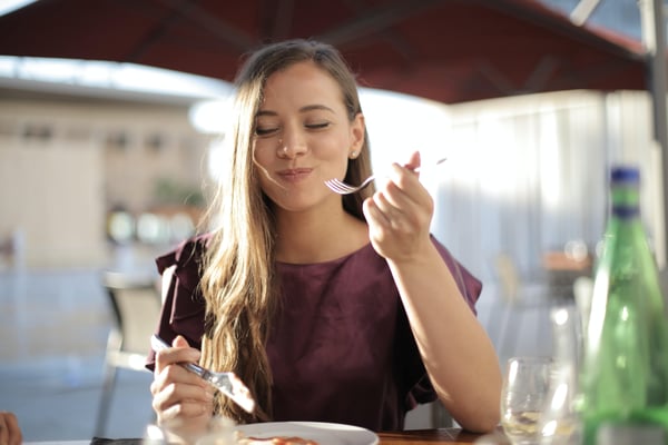 Woman eating at a restaurant outside